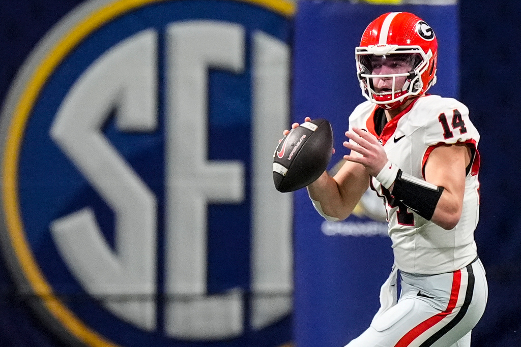 Georgia quarterback Gunner Stockton (14) rolls out of the p[ocket against Alabama during the second half of a Southeastern Conference championship NCAA college football game, Saturday, Dec. 6, 2025, in Atlanta. (AP Photo/Mike Stewart)