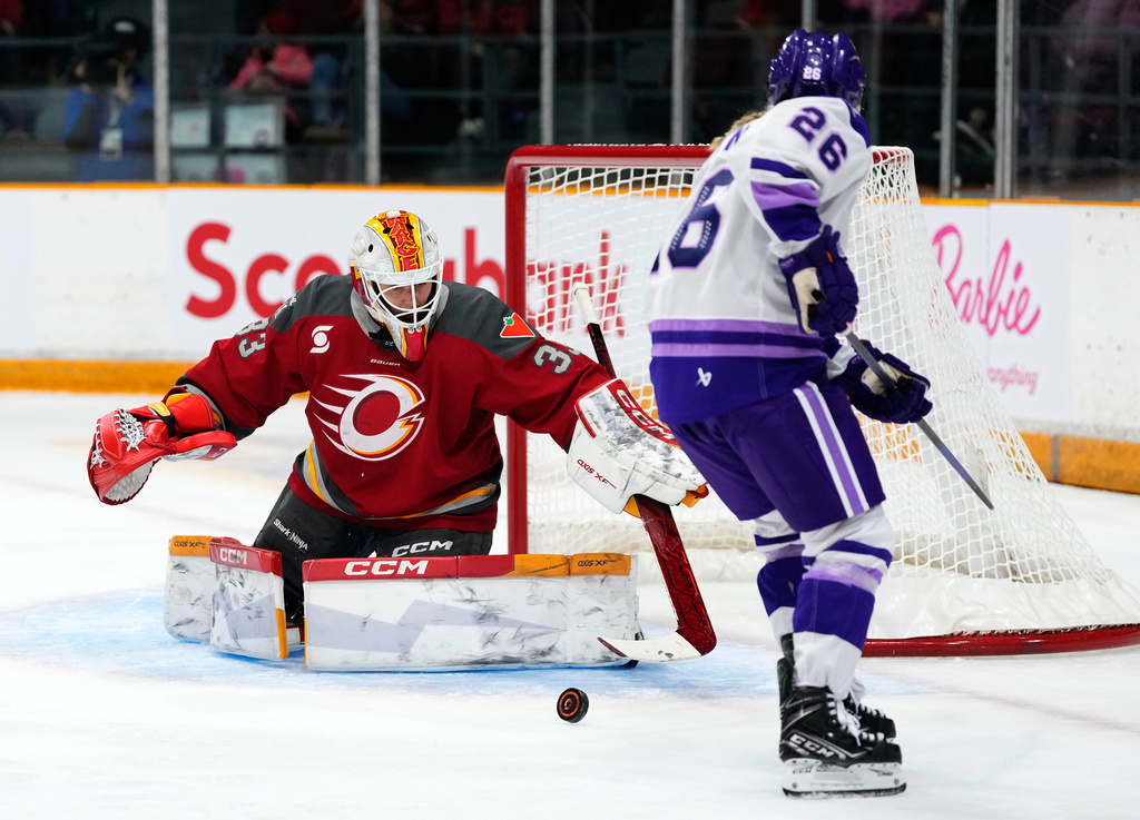Ottawa Charge goaltender Gwyneth Philips, left, makes a save on Minnesota Frost's Kendall Coyne Schofield (26) during the second period of a PWHL hockey game in Ottawa, Ontario, Tuesday, Dec. 2, 2025. (Justin Tang/The Canadian Press via AP)