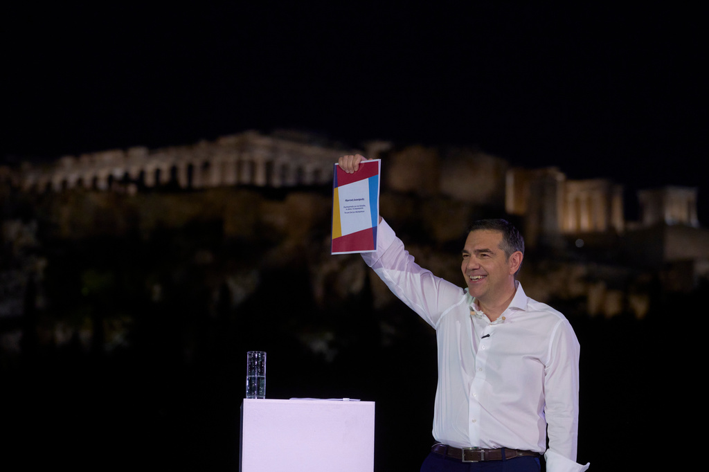 Former left-wing Prime Minister Alexis Tsipras holds the founding manifesto of his new political party as speaks to supporters in front of the ancient Acropolis , ahead of elections next year, in Athens, on Tuesday, May 26, 2026. (AP Photo/Petros Giannakouris)