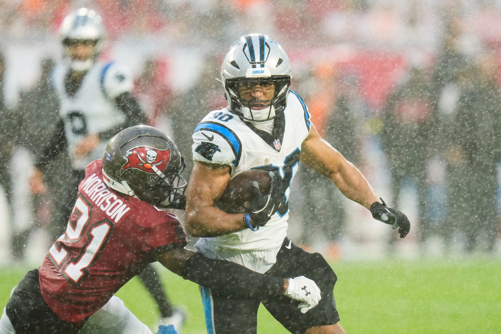 Carolina Panthers running back Chuba Hubbard (30) runs around the tackle attempt from Tampa Bay Buccaneers cornerback Benjamin Morrison (21) during the first half of an NFL football game Saturday, Jan. 3, 2026, in Tampa, Fla. (AP Photo/Chris O'Meara)