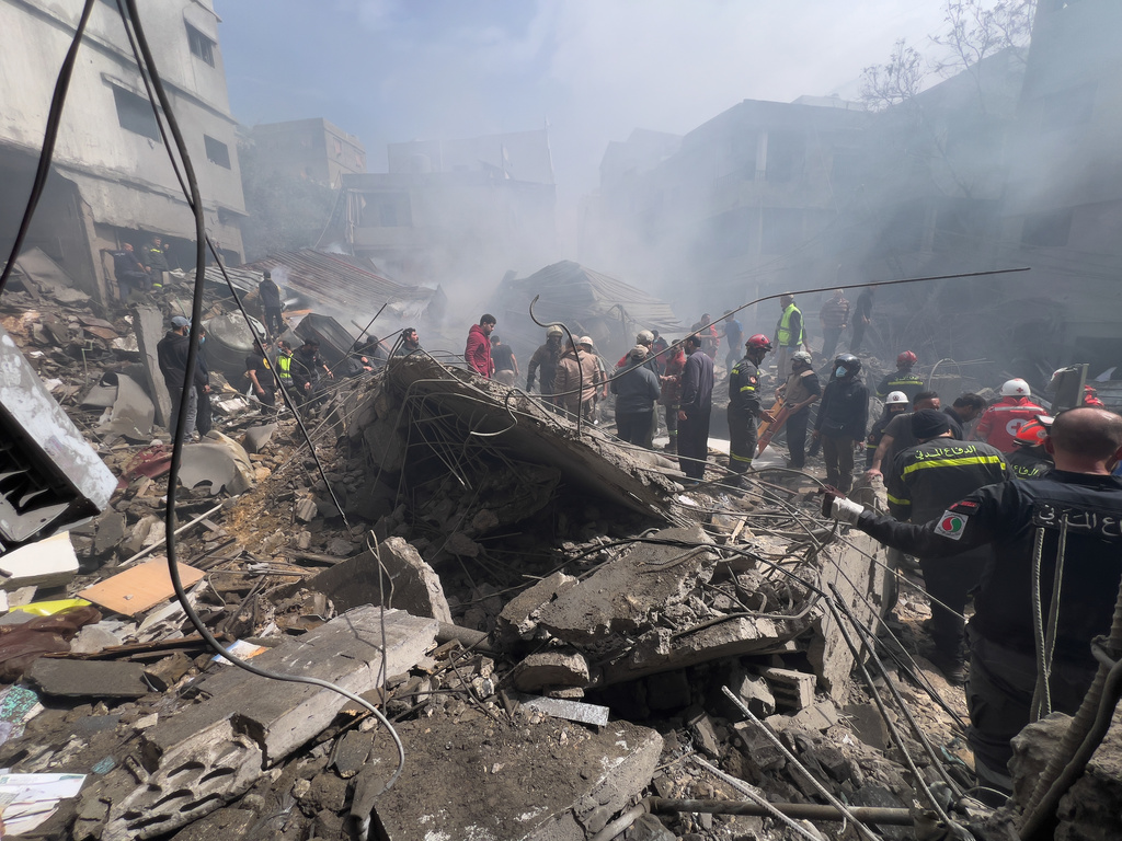 Rescue workers search for victims at the site of an Israeli airstrike that hit a crowded neighbourhood south of Beirut, Lebanon, Sunday, April 5, 2026. (AP Photo/Hussein Malla)