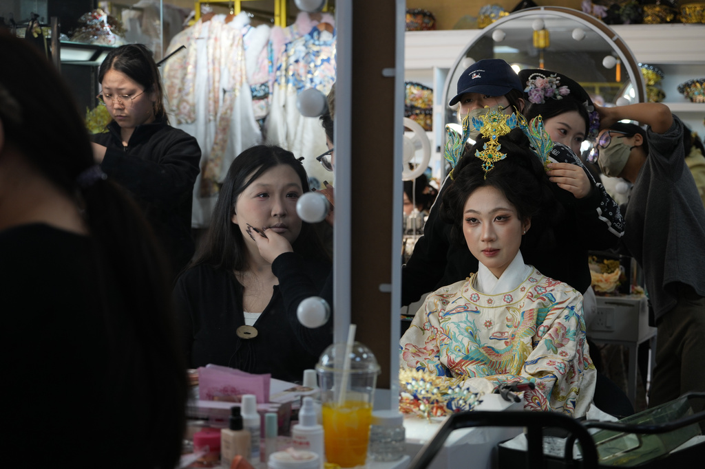 Women get made up with historical Chinese costumes at studio near the Forbidden City in Beijing on Saturday, April 4, 2026. (AP Photo/Ng Han Guan)