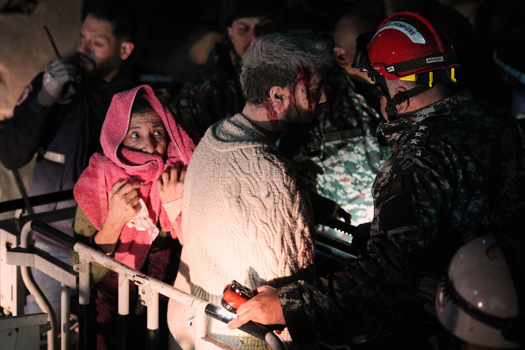 A woman and an injured man, center, are rescued by firefighters from a destroyed building that was hit in an Israeli airstrike in central Beirut, Lebanon, Wednesday, April 8, 2026. (AP Photo/Emilio Morenatti)