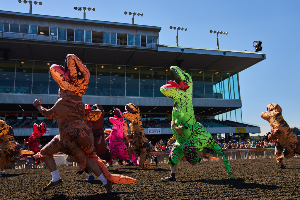 Participants sprint to the finish line during the teen race during the T-Rex World Championship Races at Emerald Downs, Sunday, July 12, 2026, in Auburn, Wash. (AP Photo/Lindsey Wasson)