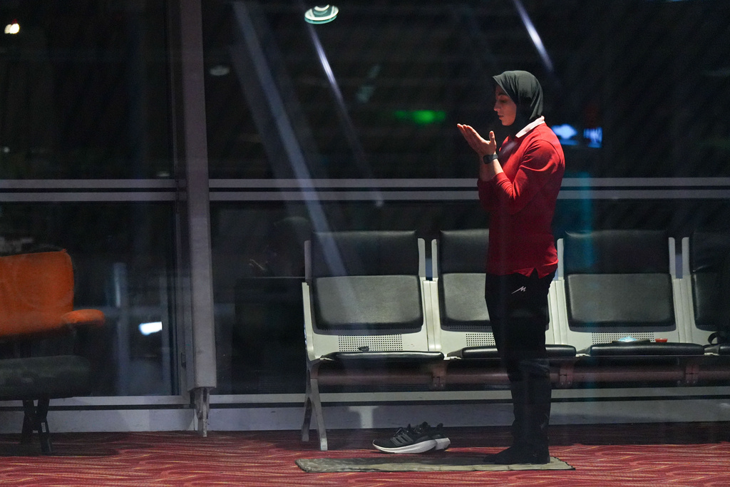 A member of Iran's women's soccer team prays at the Kuala Lumpur International Airport in Sepang, Malaysia, Monday, March 16, 2026. (AP Photo/Azneal Ishak)