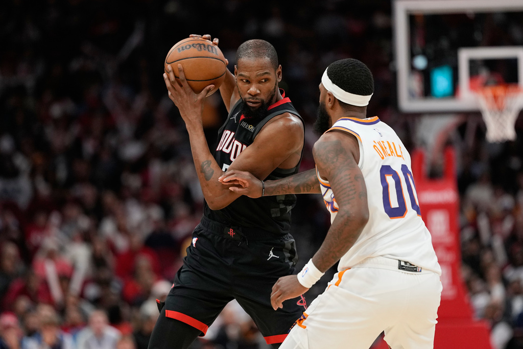 Houston Rockets' Kevin Durant, left, is defended by Phoenix Suns' Royce O'Neale (00) during the second half of an NBA basketball game Monday, Jan. 5, 2026, in Houston. (AP Photo/David J. Phillip)