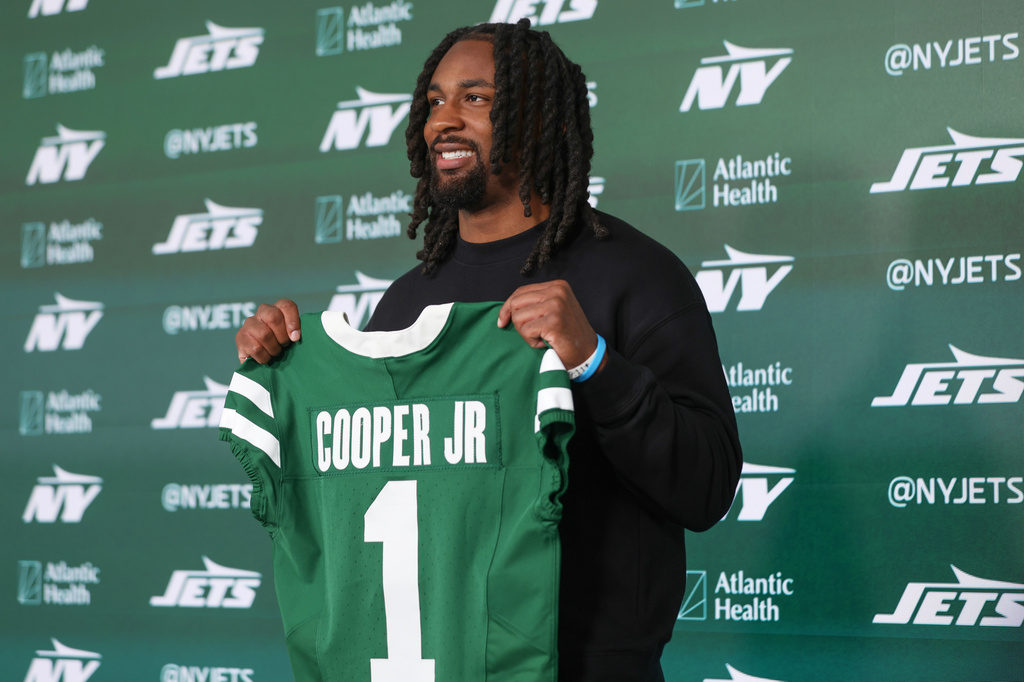 New York Jets first round draft pick, No. 30 overall, Omar Cooper Jr. holds up a jersey during an introductory press conference at the NFL team's training facility, Friday, April 24, 2026, in Florham Park, N.J. (AP Photo/Heather Khalifa)