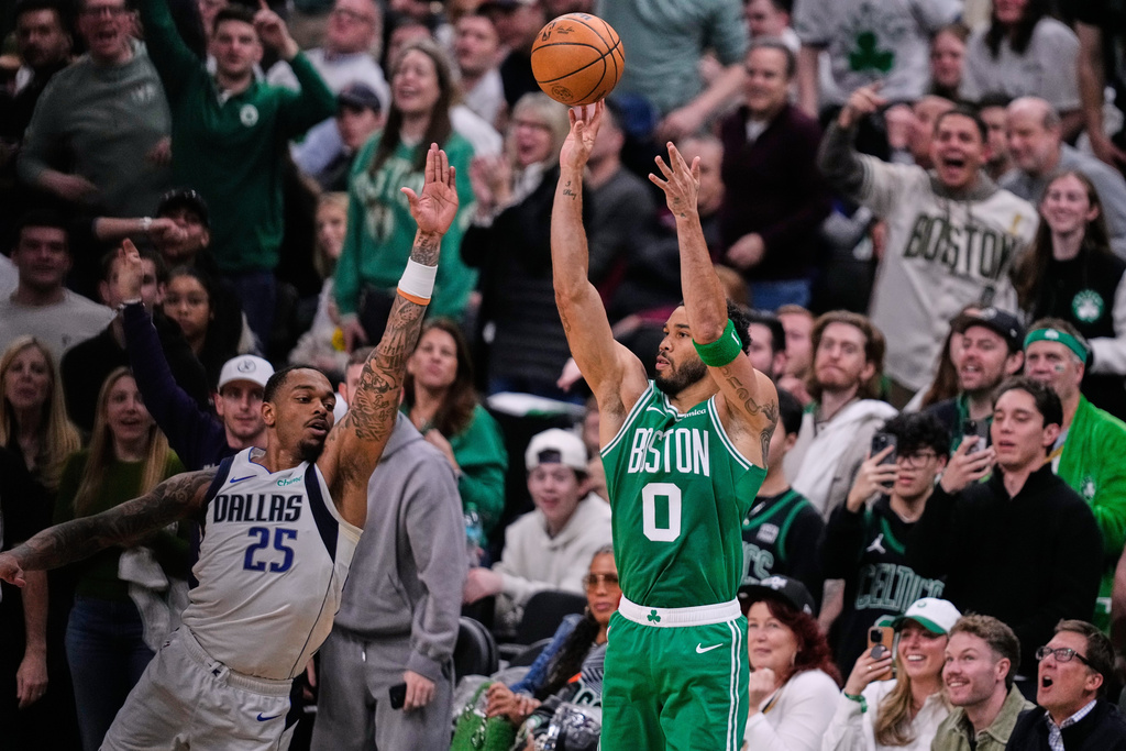 Boston Celtics forward Jayson Tatum (0) takes a 3-point shot against Dallas Mavericks forward P.J. Washington (25) during the first half of an NBA basketball game, Friday, March 6, 2026, in Boston. (AP Photo/Charles Krupa)