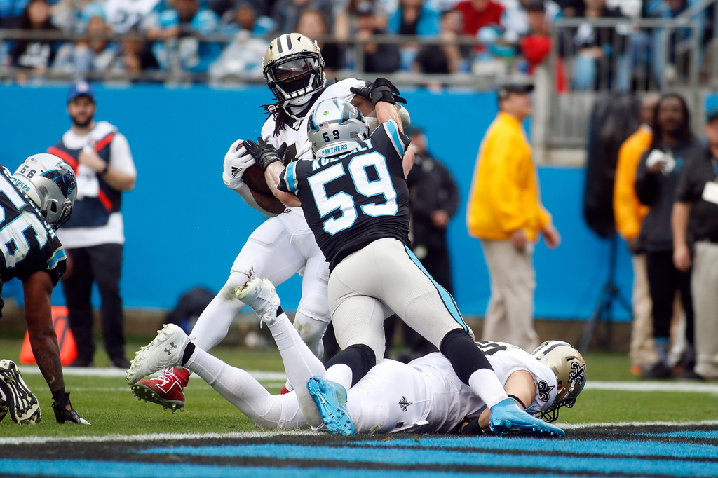 FILE - Carolina Panthers middle linebacker Luke Kuechly (59) makes an attempt to tackle New Orleans Saints running back Alvin Kamara as he runs the ball for a touchdown during the first half of an NFL football game in Charlotte, N.C., Sunday, Dec. 29, 2019. (AP Photo/Brian Blanco,File)