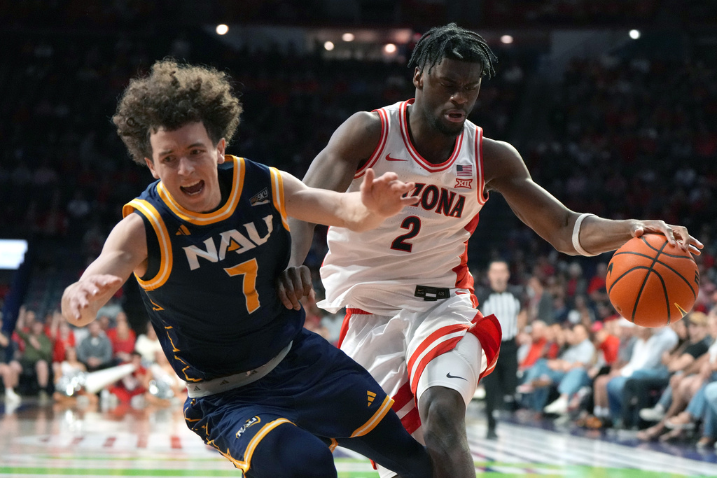 Arizona guard Dwayne Aristode gets fouled by Northern Arizona guard Brennan Peterson (7) during the first half of an NCAA college basketball game, Tuesday, Nov. 11, 2025, in Tucson, Ariz. (AP Photo/Rick Scuteri)