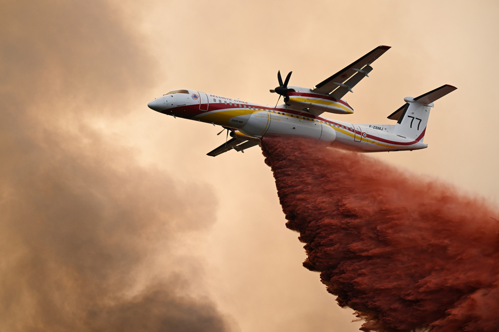 A De Havilland Canada Dash 8-400 drops fire retardant over a forest near Saint-Jean-d'Illac, during wildfires in southwestern France, Tuesday, July 28, 2026. (AP Photo/Emma Da Silva)