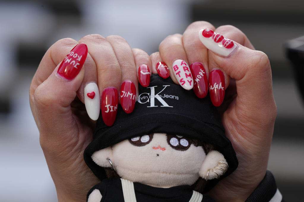 Yumika Ueno, a Japanese fan of K-pop band BTS, poses for a photo with her painted nails showing the names of BTS members at Gwanghwamun Square in Seoul, South Korea, Thursday, March 19, 2026. (AP Photo/Lee Jin-man)
