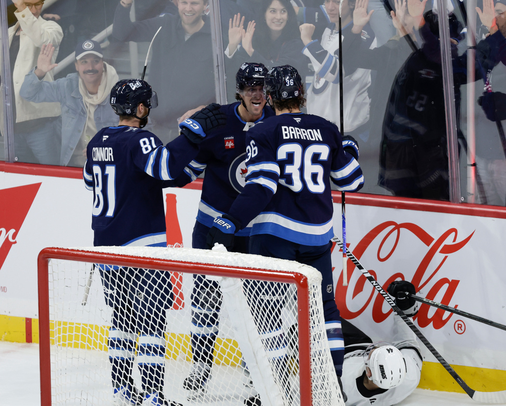 Winnipeg Jets' Morgan Barron (36), Kyle Connor (81) and Mark Scheifele (55) celebrate Scheifele's goal against Los Angeles Kings goaltender Darcy Kuemper (35) during the second period of an NHL game in Winnipeg, Manitoba, Saturday, Oct. 11, 2025. (John Woods/The Canadian Press via AP)