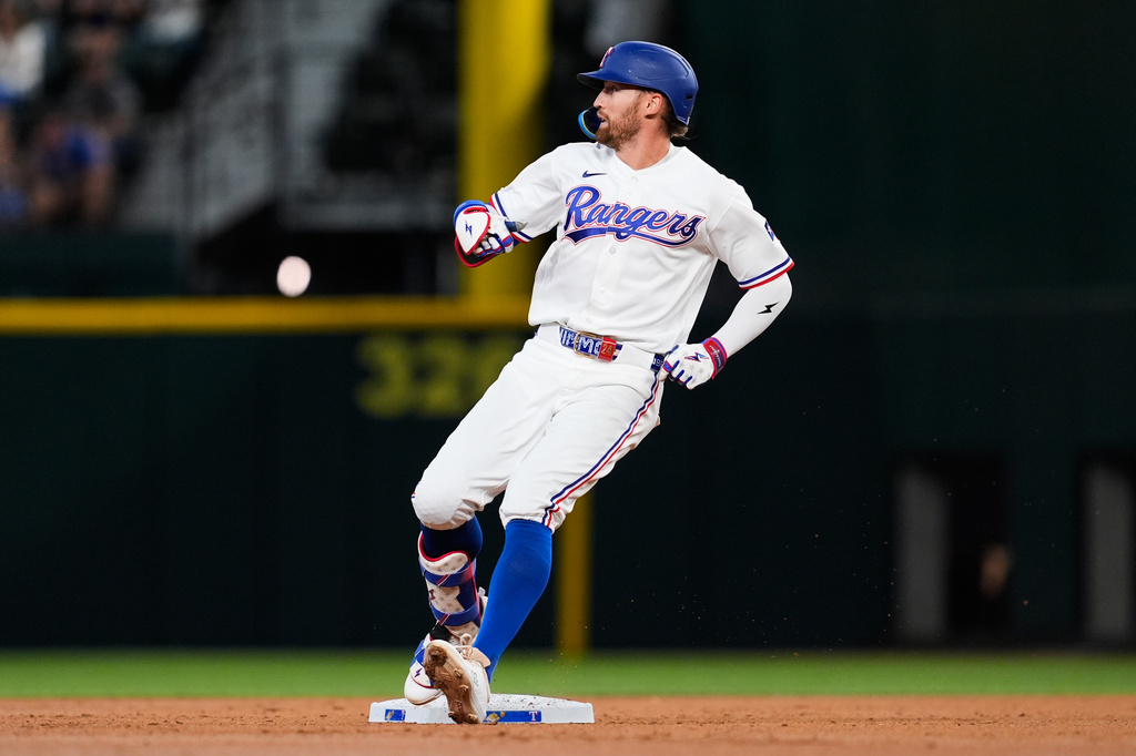 Texas Rangers' Brandon Nimmo reaches the bag after hitting a double in the third inning of a baseball game against the Seattle Mariners Wednesday, April 8, 2026, in Arlington, Texas. (AP Photo/Tony Gutierrez)