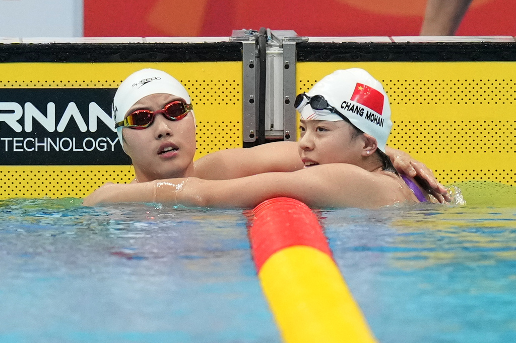Yu Zidi of China, left, and Chang Mohan of China reach towards each other after competing in swimming at the Asian Games in Tokyo, Japan, Sunday, Sept. 20, 2026. (AP Photo/Hiro Komae)