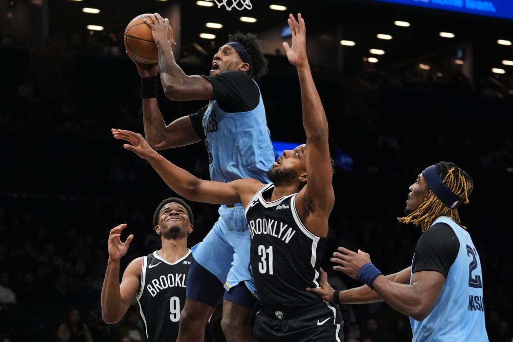 Memphis Grizzlies' Olivier-Maxence Prosper, center, drives past Brooklyn Nets' Chaney Johnson, right, and E.J. Liddell during the second half of an NBA basketball game Monday, March 9, 2026, in New York. (AP Photo/Frank Franklin II)