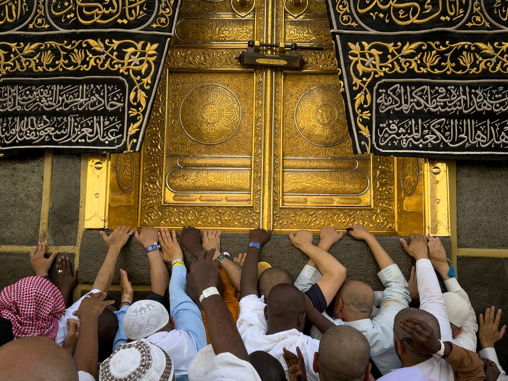 Muslim pilgrims try to touch the door of the Kaaba, Islam's holiest site, as they perform the farewell circumambulation called Tawaf al-Wada at the Grand Mosque during the final rites of the annual Hajj pilgrimage in Mecca, Saudi Arabia, Friday, May 29, 2026. (AP Photo/Altaf Qadri)
