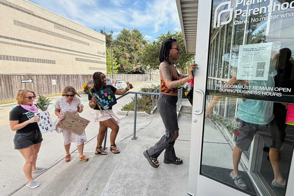 Members of Louisiana Coalition for Reproductive Freedom and supporters arrive at Planned Parenthood on the day they are closing, to deliver cards and flowers to the organization, in New Orleans, Tuesday, Sept. 30, 2025. (AP Photo/Gerald Herbert)