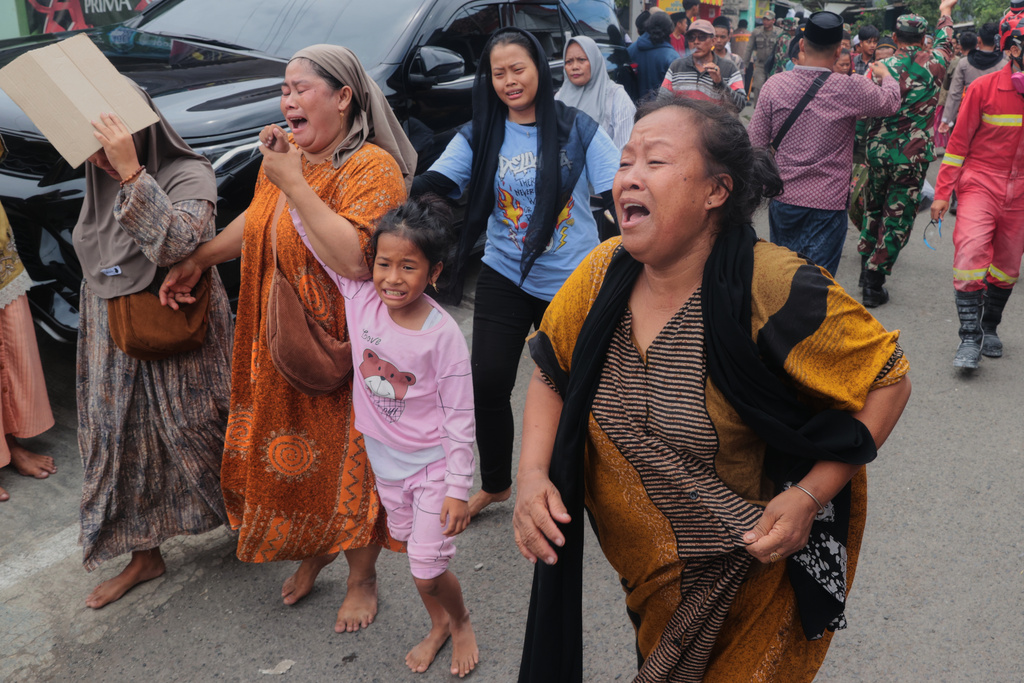 Women react as they move away after a building collapsed at an Islamic boarding school in Sidoarjo, East Java, Indonesia, Tuesday, Sept. 30, 2025. (AP Photo/Trisnadi)
