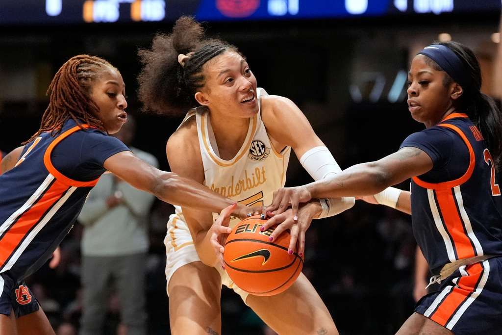 Vanderbilt guard Ndjakalenga Mwenentanda, center, battles Auburn guards Kaitlyn Duhon, left, and Ja'mia Harris (2) for the ball during the first half of an NCAA college basketball game Thursday, Jan. 22, 2026, in Nashville, Tenn. (AP Photo/George Walker IV)