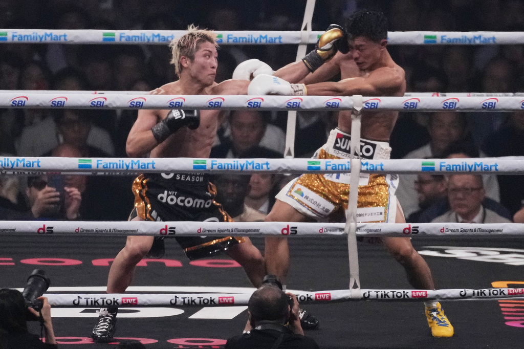 Naoya Inoue of Japan, left, punches Junto Nakatani of Japan during the twelfth round of a boxing match for the WBA, WBC, IBF and WBO super bantamweight world title in Tokyo, Saturday, May 2, 2026. (AP Photo/Hiro Komae)