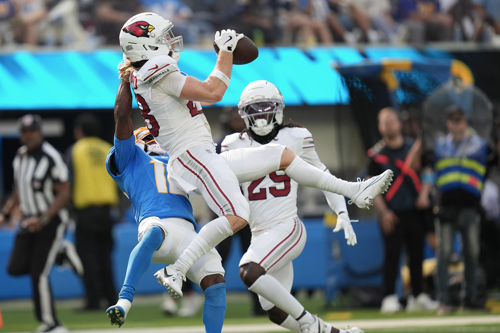 Arizona Cardinals safety Andrew Wingard, top, intercepts a pass intended for Los Angeles Chargers wide receiver Derius Davis, left, during the second half of an NFL football game, Sunday, Sept. 13, 2026, in Inglewood, Calif. (AP Photo/Gregory Bull)