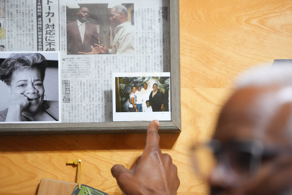 Richard Miles, founder and CEO of Miles of Freedom, a Dallas-based group that provides help for individuals after they have been released from prison, whether they are on parole or are exonerees, points to a photograph of his family members visiting in prison during an interview with The Associated Press, Tuesday, April 21, 2026 in Dallas. (AP Photo/Julio Cortez)