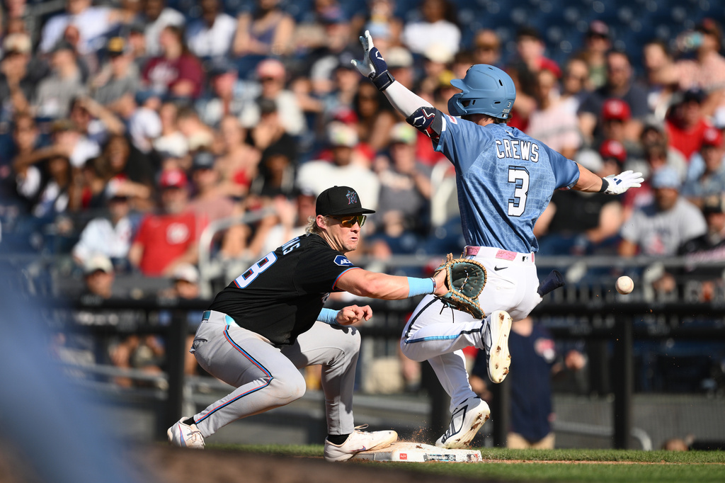 Washington Nationals' Dylan Crews (3) is safe at first base with a single against Miami Marlins first baseman Kyle Stowers, left, during the third inning of a baseball game, Saturday, Aug. 29, 2026, in Washington. (AP Photo/Nick Wass)