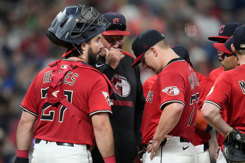Cleveland Guardians pitching coach Carl Willis, center, and catcher Austin Hedges (27) talk with starting pitcher Parker Messick, right, in the fifth inning of a baseball game against the Detroit Tigers in Cleveland, Thursday, Sept. 25, 2025. (AP Photo/Sue Ogrocki)
