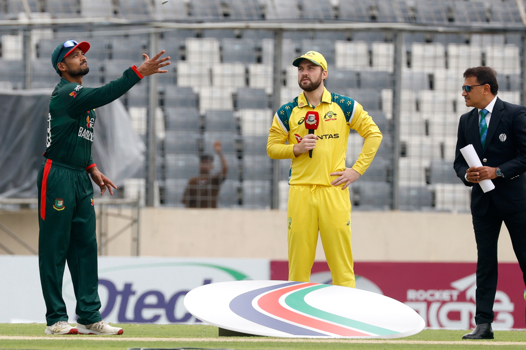 Bangladesh's captain Mehidy Hasan Miraz, left toss the coin as Australia's captain Josh Inglis looks on during the third one day international cricket match between Australia and Bangladesh, in Mirpur, India, Saturday, June 13, 2026. (AP Photo/Mosaraf Hossain)