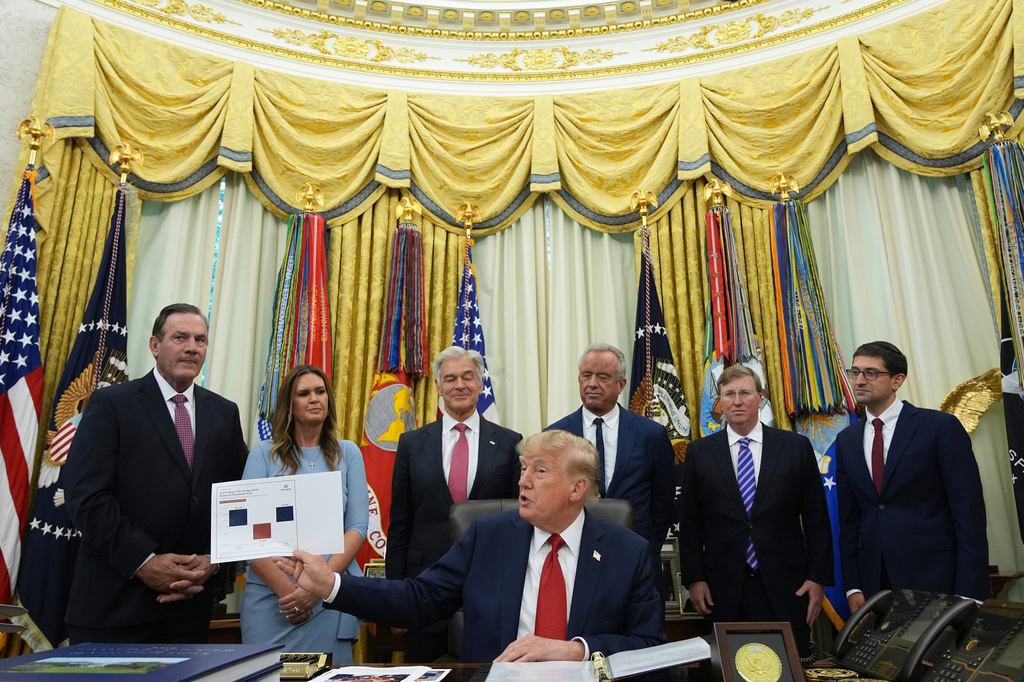 President Donald Trump speaks as South Dakota Gov. Larry Rhoden, from left, Arkansas Gov. Sarah Huckabee Sanders, Mehmet Oz, administrator of the Centers for Medicare & Medicaid Services, Health and Human Services Secretary Robert F. Kennedy Jr., Mississippi Gov. Tate Reeves and Abe Sutton, director of the Center for Medicare and Medicaid Innovation, listen during an event about healthcare in the Oval Office of the White House, Friday Sept. 18, 2026, in Washington. (AP Photo/Jacquelyn Martin)
