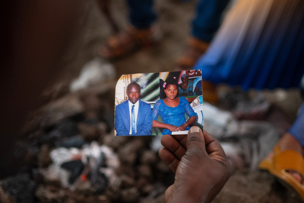 People look at pictures of Nguvumali Kalabosh Bosco, who died when tunnels collapsed at a major coltan mining site due to landslides, in Goma, eastern Congo, Monday, Feb. 2, 2026. (AP Photo/Moses Sawasawa)