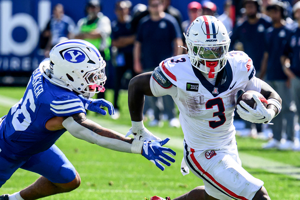 Arizona running back Kedrick Reescano (3) runs the ball past the attempted tackle of BYU linebacker Isaiah Glasker (16) during the first half an NCAA college football game Saturday, Sept. 12, 2026, in Provo, Utah. (AP Photo/Tyler Tate)