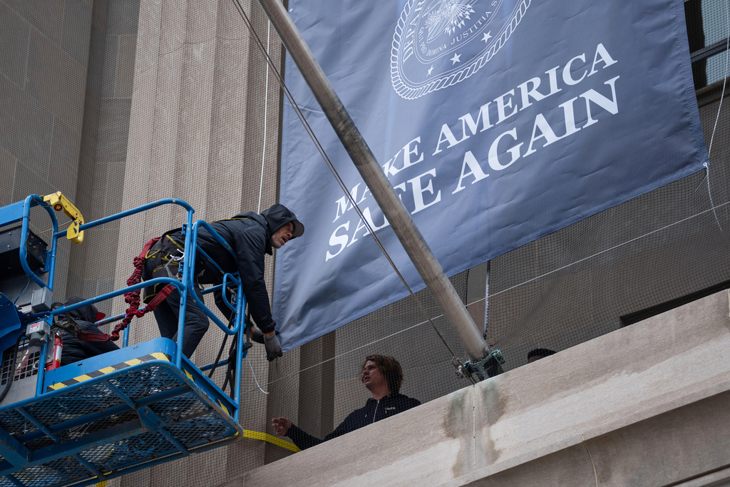 A banner showing President Donald Trump is hung from the Department of Justice, Thursday, Feb. 19, 2026, in Washington. (AP Photo/Allison Robbert)