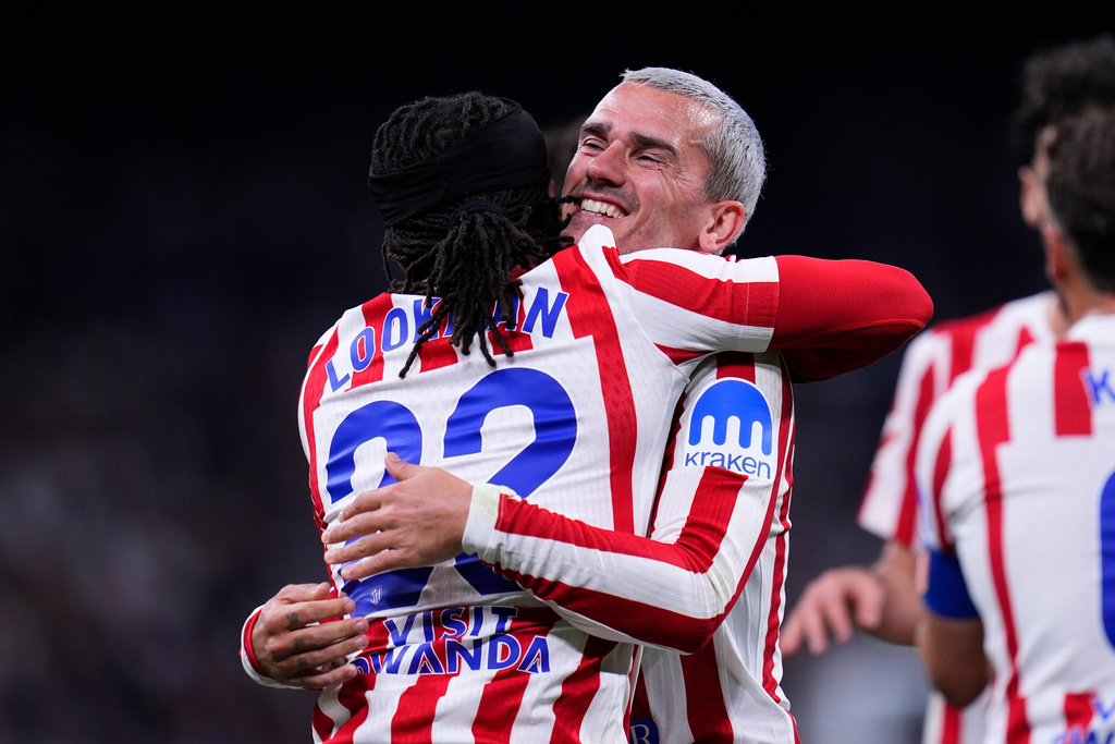 Atletico Madrid's Ademola Lookman, left, celebrates with Antoine Griezmann after scoring the opening goal during the Spanish La Liga soccer match between Real Madrid and Atletico Madrid in Madrid, Spain, Sunday, March 22, 2026. (AP Photo/Manu Fernandez)