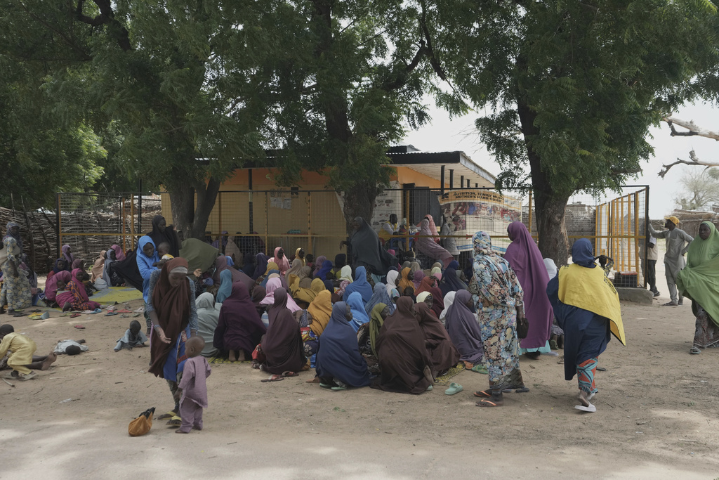 Women waits to be attended to at a facility run by aid group International Rescue Committee, in Magumeri, in northeast Nigeria's Borno state, Tuesday, July 22, 2025. (AP Photo/Sunday Alamba)