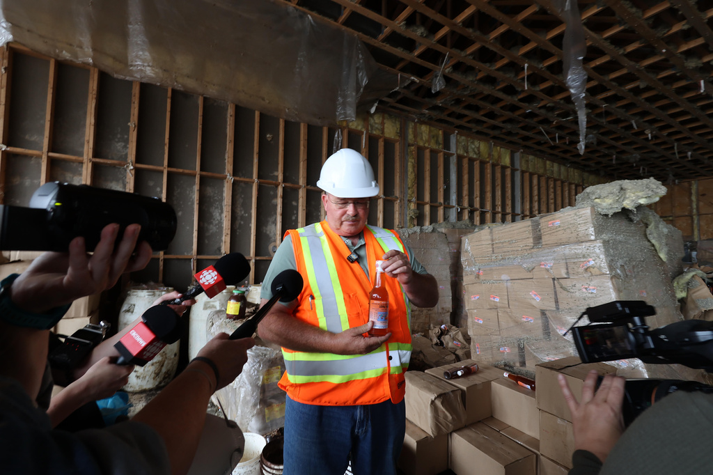 Glenn Sharp, owner of Sharp Management, is shown holding a bottle of fish sauce in the abandoned plant in St. Mary's, N.L., on Tuesday July 28, 2026. (Elling Lien/The Canadian Press via AP)