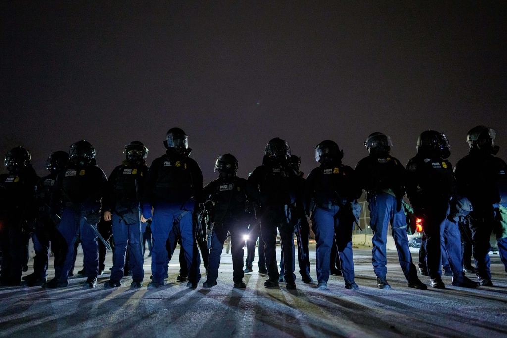 Federal immigration officers confront protesters outside Bishop Henry Whipple Federal Building, Thursday, Jan. 15, 2026, in Minneapolis. (AP Photo/Adam Gray)