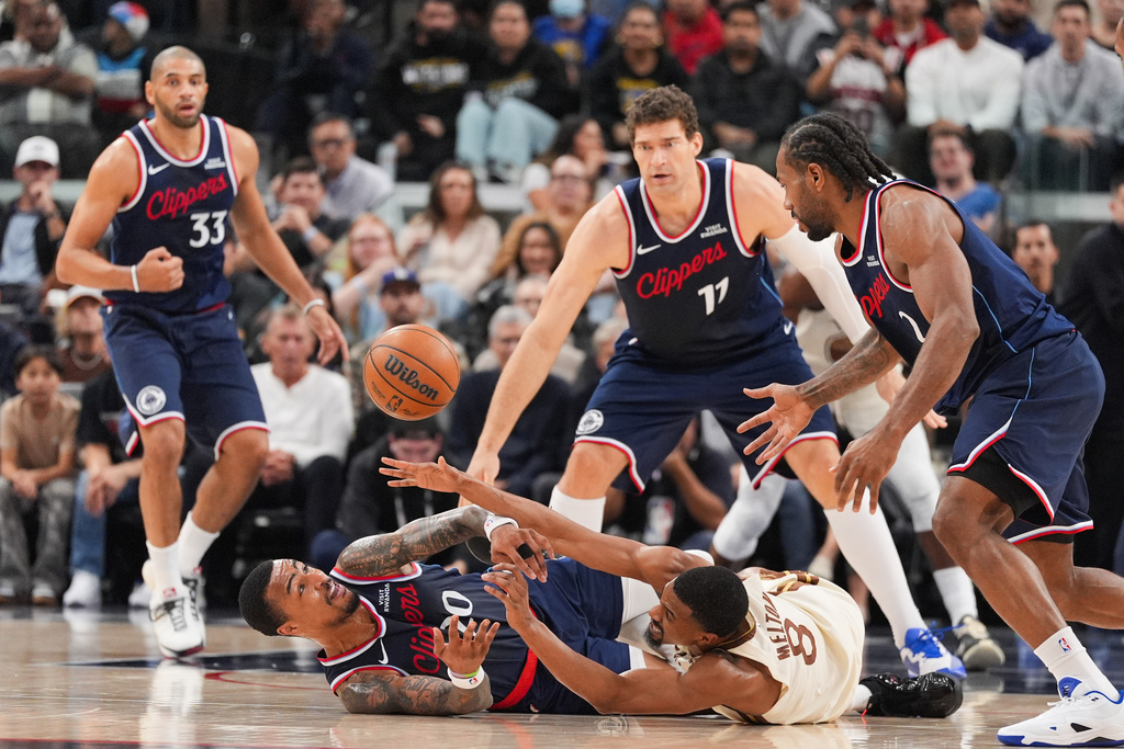 Los Angeles Clippers forward/center John Collins (20) and Golden State Warriors guard De'anthony Melton (8) scramble on the court for a loose ball during the first half of an NBA basketball game Monday, Jan. 5, 2026, in Inglewood, Calif. (AP Photo/Jae C. Hong)
