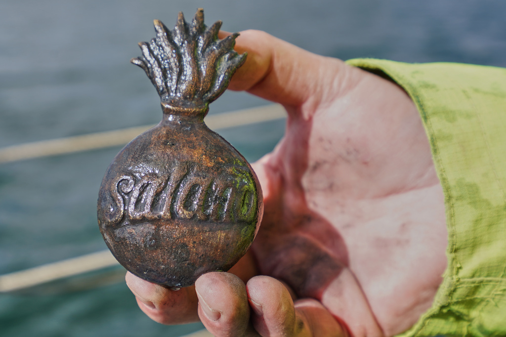 Morten Johansen, head of maritime archaeology at Denmark's Viking Ship Museum, shows a metal insignia recovered from the wreck of Danish flagship "Dannebroge" that sank during the Battle of Copenhagen in 1801, in Copenhagen, Denmark, Tuesday, March 31, 2026. (AP Photo/James Brooks)