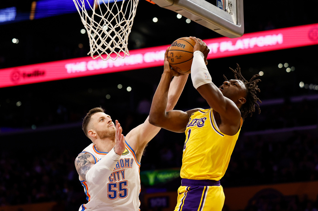 Los Angeles Lakers forward Adou Thiero (1) drives to the basket with the ball while being guarded by Oklahoma City Thunder center Isaiah Hartenstein (55) during the first half of an NBA basketball game Tuesday, April 7, 2026, in Los Angeles. (AP Photo/Caroline Brehman)