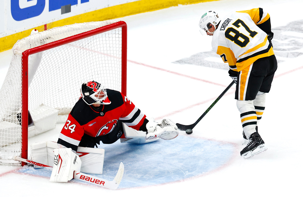 New Jersey Devils goaltender Jake Allen (34) defends against a shot by Pittsburgh Penguins center Sidney Crosby (87) during the third period of an NHL hockey game, Thursday, April 9, 2026, in Newark, N.J. (AP Photo/Noah K. Murray)