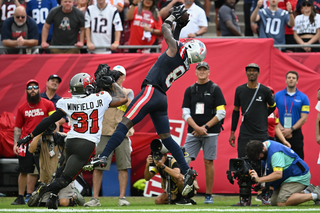 New England Patriots wide receiver Stefon Diggs (8) catches a pass for a touchdown against Tampa Bay Buccaneers safety Antoine Winfield Jr. (31) during the first half of an NFL football game Sunday, Nov. 9, 2025, in Tampa, Fla. (AP Photo/Jason Behnken)