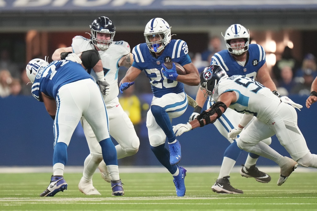 Indianapolis Colts running back Jonathan Taylor (28) runs past Tennessee Titans linebacker Cody Barton (50) during the first half an NFL football game, Sunday, Oct. 26, 2025, in Indianapolis. (AP Photo/AJ Mast)