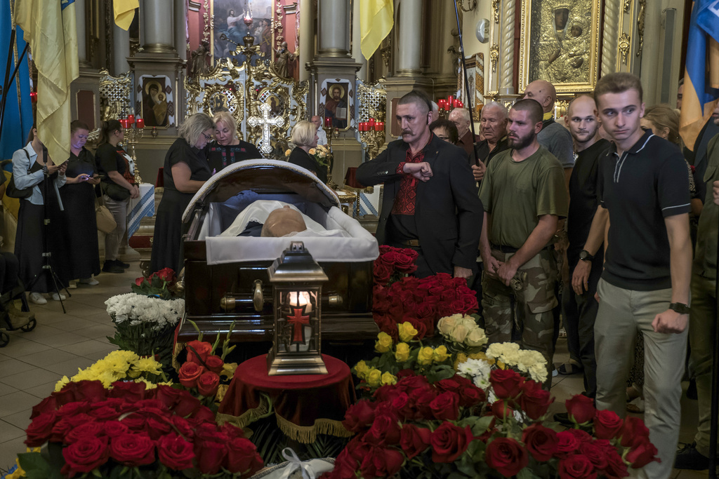 People mourn near the coffin of former Ukrainian parliament speaker Andriy Parubiy, who was killed last Saturday in Lviv, Ukraine, Tuesday, Sept. 2, 2025. (AP Photo/Vladyslav Musiienko)