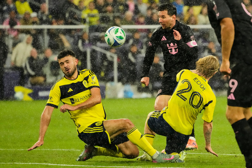 Nashville SC midfielders Patrick Yazbek, left, and midfielder Edvard Tagseth (20) block a shot on goal by Inter Miami forward Lionel Messi, center, during the first half of Game 2 in the first round of MLS soccer Eastern Conference playoff Saturday, Nov. 1, 2025, in Nashville, Tenn. (AP Photo/George Walker IV)