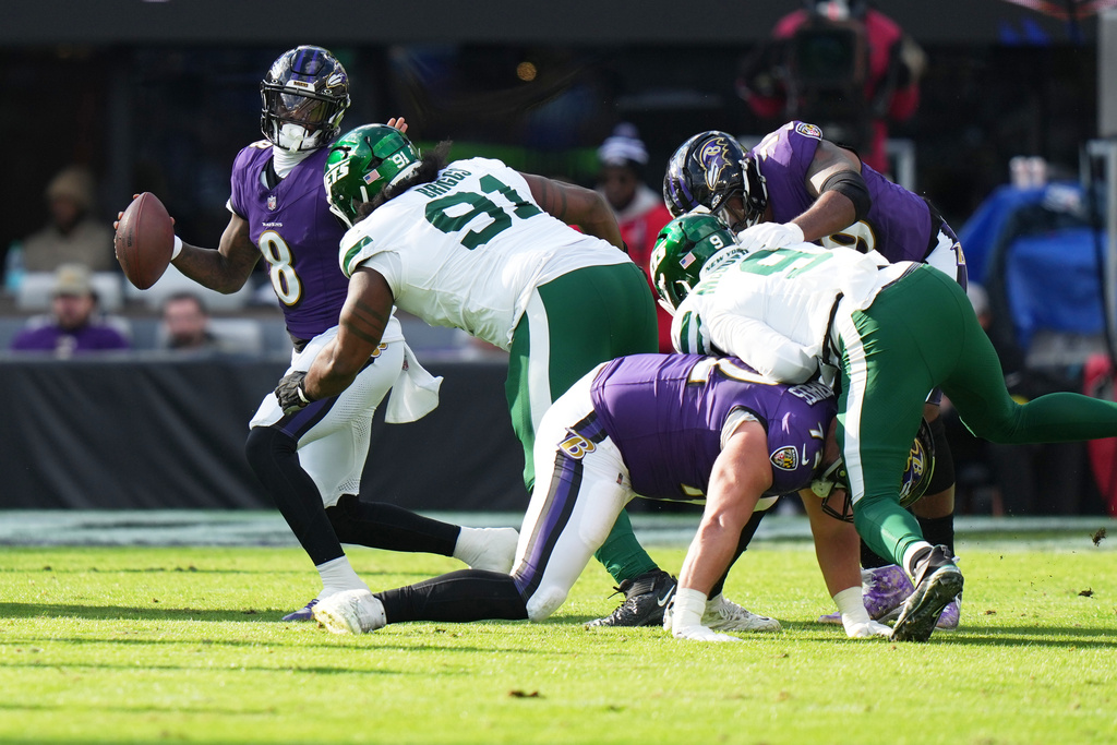 Baltimore Ravens quarterback Lamar Jackson (8) scrambles before being sacked by New York Jets defensive tackle Jowon Briggs (91) during the first half of an NFL football game, Sunday, Nov. 23, 2025, in Baltimore. (AP Photo/Stephanie Scarbrough)