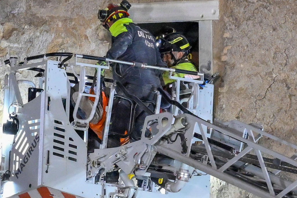 Firefighters pull a construction worker from under the debris of a medieval tower, which was under renovation near the Roman Forum in Rome, Monday, Nov. 3, 2025, after it partially collapsed in the morning. (Fabrizio Corradetti/LaPresse via AP)
