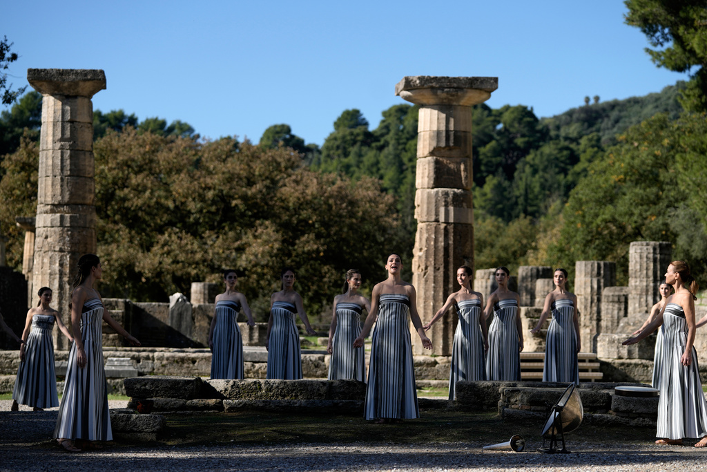 Actor Mary Mina playing the role of high priestess, center, performs during a rehearsal ahead of the flame lighting for the Milan Cortina 2026 Winter Olympics, at the Ancient Olympia site, Greece, Monday, Nov. 24, 2025. (AP Photo/Thanassis Stavrakis)
