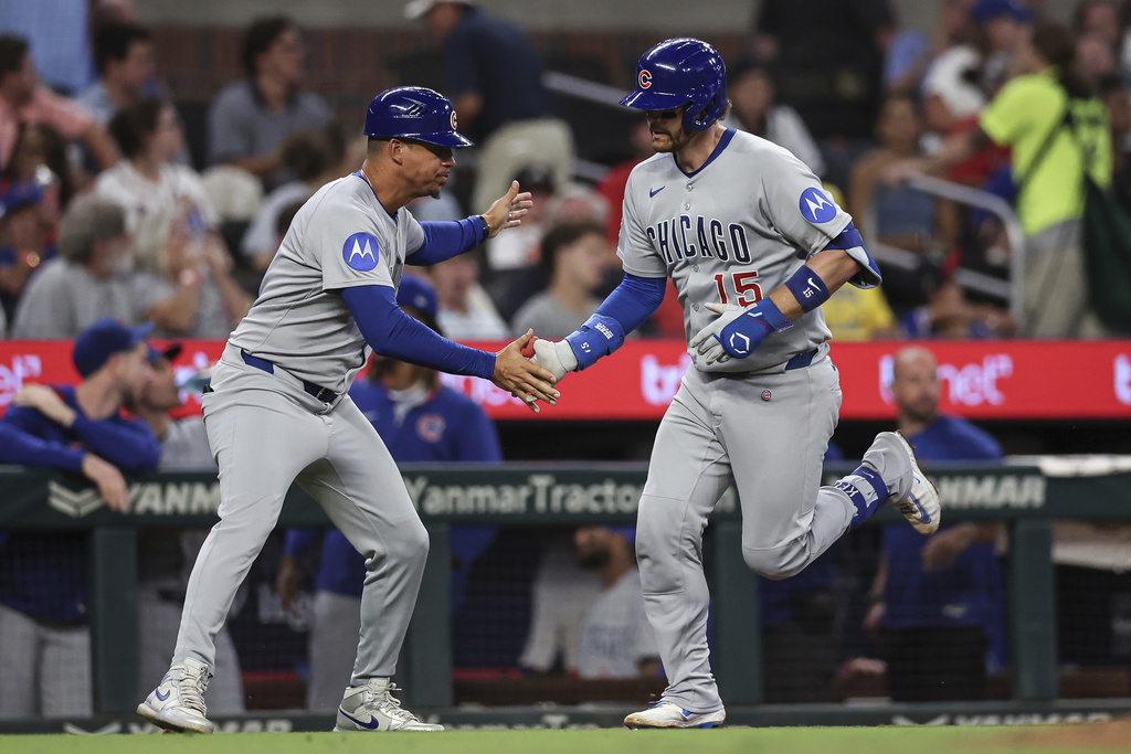 Chicago Cubs' Carson Kelly (15) high-fives third base coach Quintin Berry after hitting a solo home run in the fourth inning of a baseball game against the Atlanta Braves, Wednesday, Sept. 10, 2025, in Atlanta. (AP Photo/Colin Hubbard)